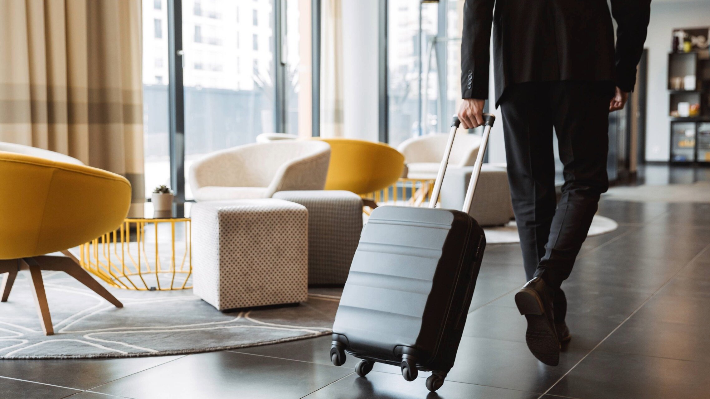 Person läuft mit Koffer durch eine Hotellobby