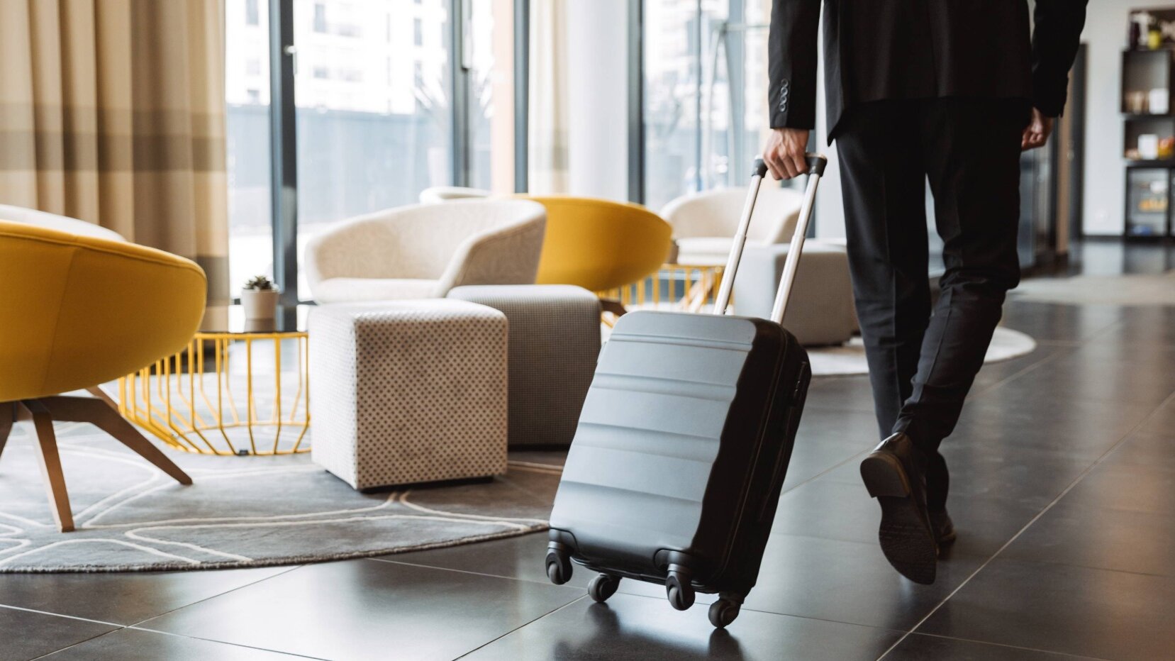 Person läuft mit Koffer durch eine Hotellobby