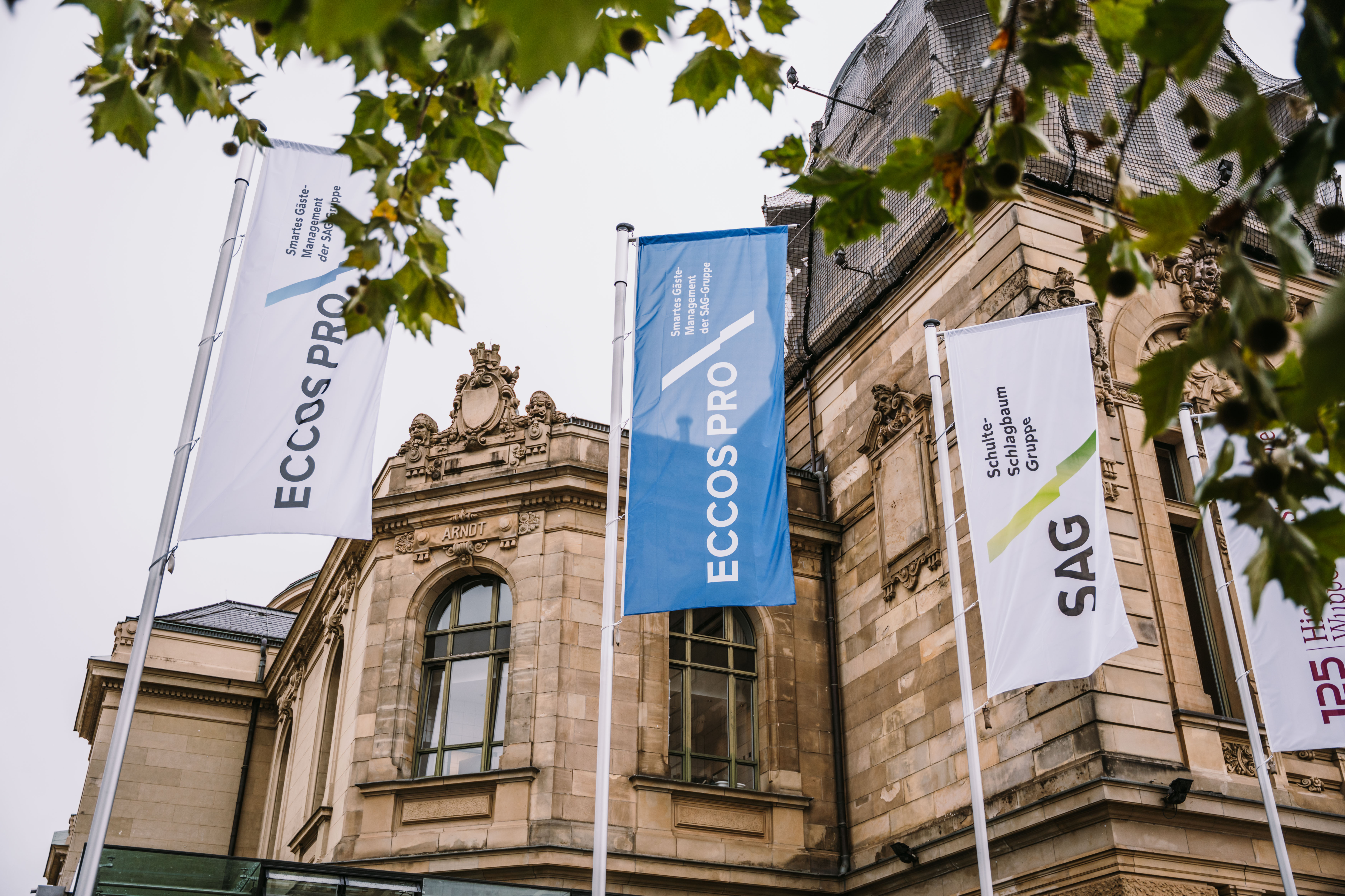 Foto von der Wuppertaler Stadthalle, im Vordergrund 4 Flaggen mit den Logos der Eccos Pro und der Schulte Schlagbaum AG 