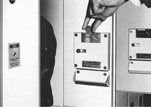 Safe-O-Mat schwarz weiß Aufnahme aus 1968. Person steckt Münze in Schloss.