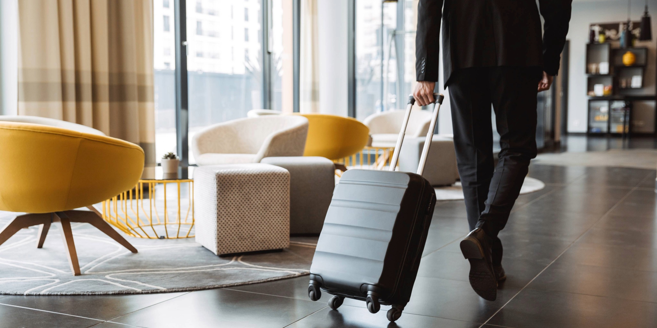 Person läuft mit Koffer durch eine Hotellobby